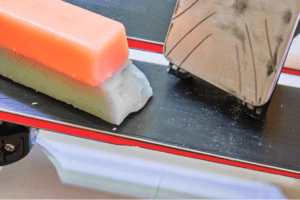 applying storage wax to skis and snowboards for off-season storage